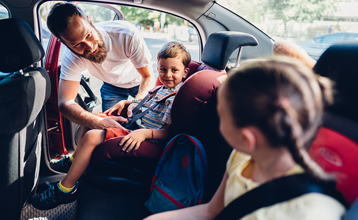 Visuel d'un père de famille et ses enfants dans une voiture