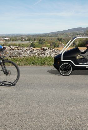 La voiture vélo de Sanka sur route de campagne avec un cycliste qui vient en sens inverse