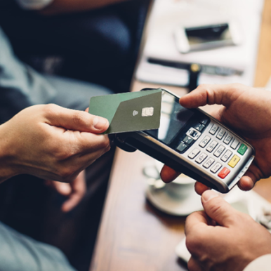 A man making a contactless payment on an electronic payment terminal