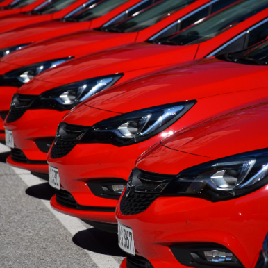 une suite de voiture rouges identiques garées les unes à côté des autres