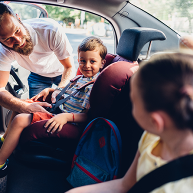 Visuel d'un père de famille et ses enfants dans une voiture